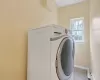 Laundry room with washer / clothes dryer and light tile patterned floors