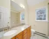 Bathroom featuring a wealth of natural light, a baseboard radiator, vanity, and toilet