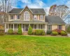 Colonial inspired home featuring a porch and a front lawn