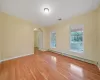 Unfurnished room with light hardwood / wood-style flooring, a healthy amount of sunlight, and a baseboard radiator