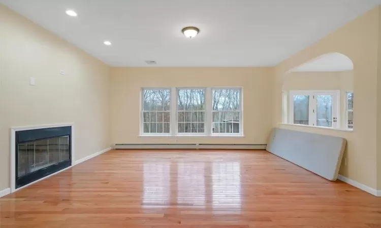 Unfurnished living room with light hardwood / wood-style flooring and baseboard heating