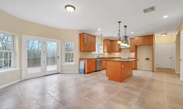 Kitchen featuring a healthy amount of sunlight, dishwasher, pendant lighting, and a kitchen island