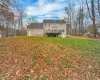 Back of house with a wooden deck and a yard