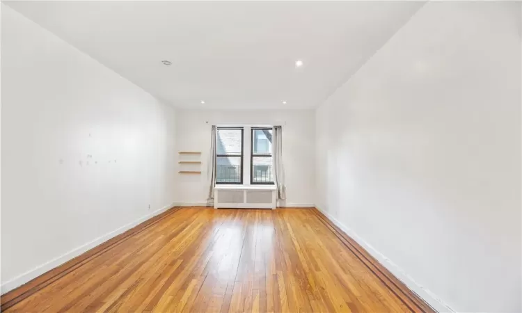 Unfurnished room with light wood-type flooring and radiator heating unit