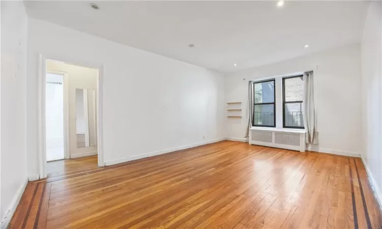 Unfurnished room with radiator and light hardwood / wood-style floors