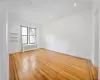 Unfurnished room with light hardwood / wood-style floors and radiator