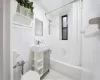 Full bathroom featuring toilet, tile walls, tile patterned flooring, sink, and shower / tub combo with curtain