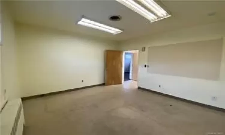 Unfurnished room with radiator heating unit and concrete floors