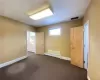 Empty room featuring a baseboard radiator and dark carpet