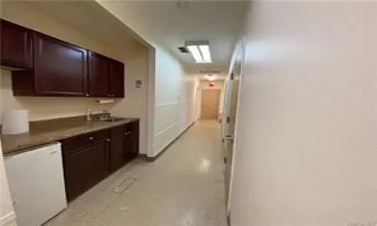 Corridor featuring sink and a skylight