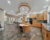 Kitchen featuring decorative backsplash, sink, stainless steel microwave, a kitchen island, and a breakfast bar