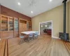 Dining space with ceiling fan, light wood-type flooring, and a wood stove