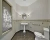 Bathroom with tile walls, tile patterned flooring, and toilet