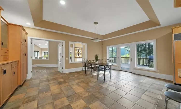 Dining room featuring light tile patterned floors and a raised ceiling