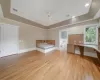 another picture of the handicapped bedroom,  light hardwood / wood-style floors, a raised ceiling, and ensuite bath