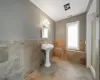 Bathroom featuring a wealth of natural light, tile walls, and tile patterned floors