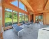 Sunroom / solarium with plenty of natural light, beamed ceiling, and a wood stove