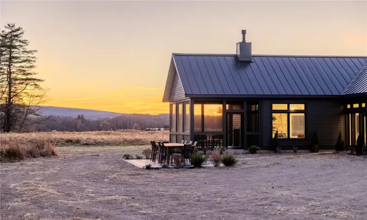 Back house at dusk with a sunroom