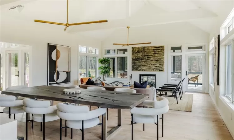 Dining area featuring light hardwood / wood-style floors, ceiling fan, a healthy amount of sunlight, and high vaulted ceiling