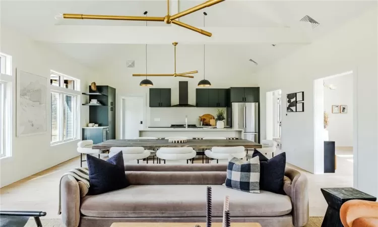 Living room with light wood-type flooring, beamed ceiling, and high vaulted ceiling