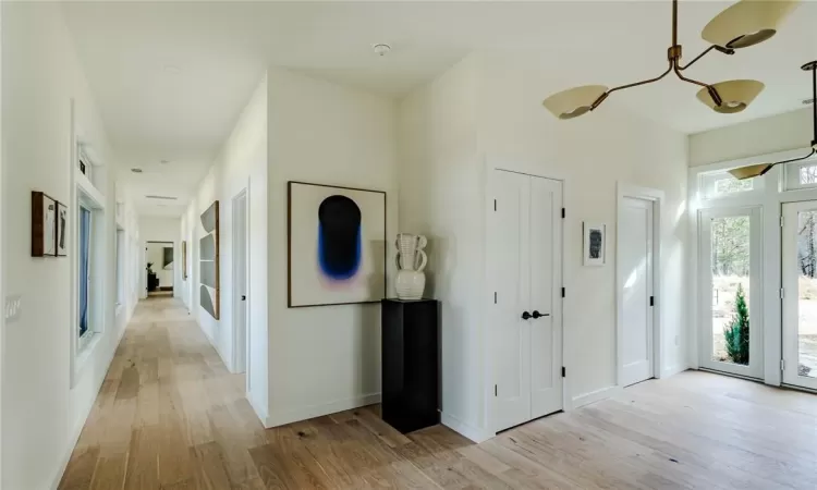 Entryway featuring light wood-type flooring and a notable chandelier