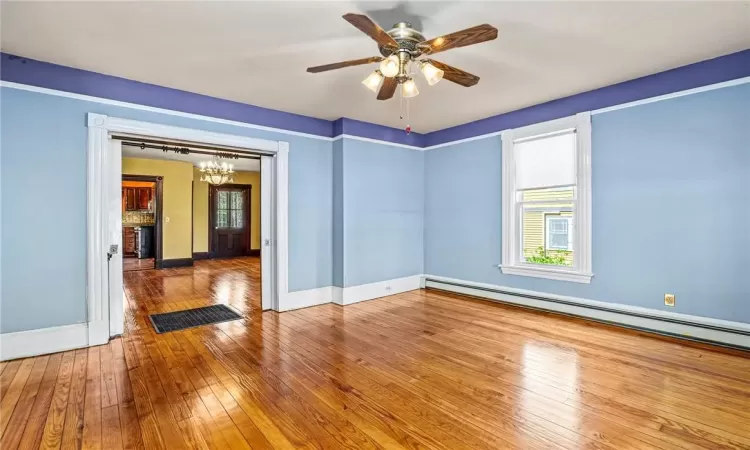 Dining room open floor plan to living room, hardwood floors and lots of windows