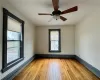 Living room featuring ceiling fan, lots of windows and hardwood floors