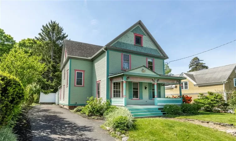 Victorian house featuring a front lawn and a porch