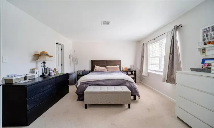 Bedroom featuring light carpet