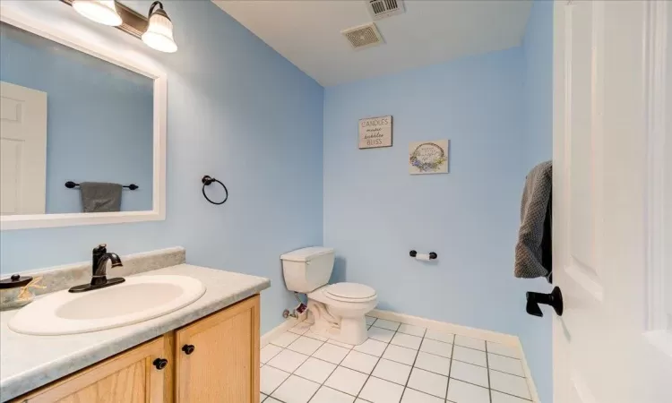 Bathroom featuring toilet, vanity, and tile patterned floors