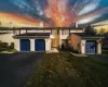 View of front facade featuring a garage and a front lawn