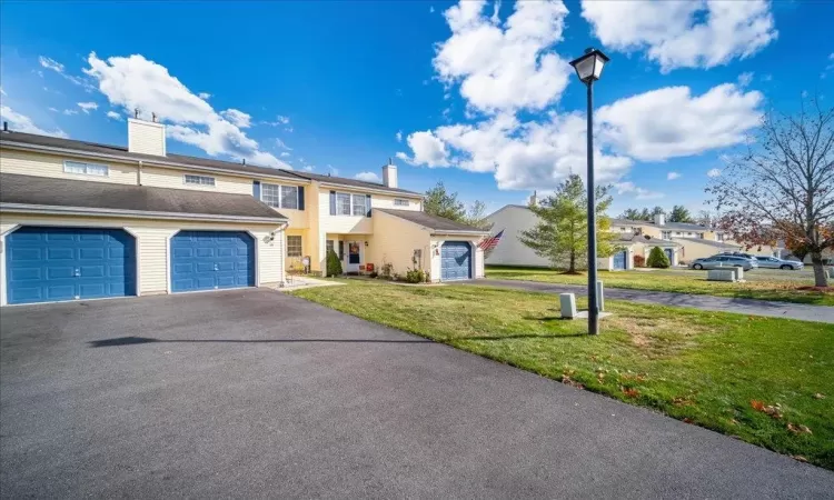 View of front facade with a garage and a yard