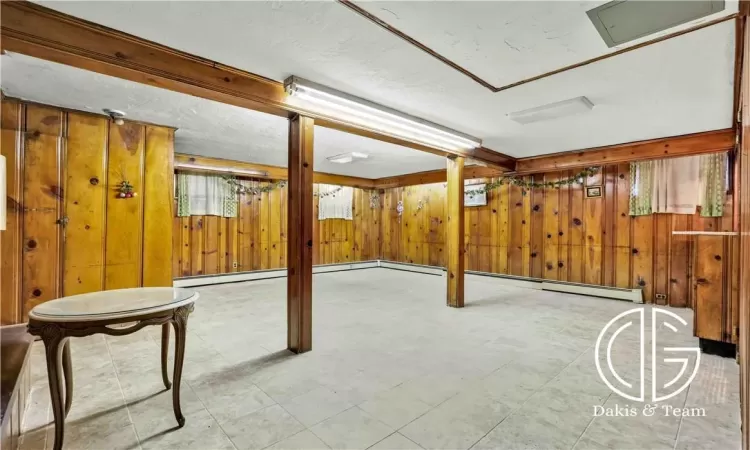 Basement featuring wooden walls and a textured ceiling