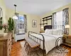 Bedroom with dark hardwood / wood-style flooring, radiator, and crown molding