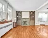 Living room featuring wood-type flooring, radiator heating unit, and a notable chandelier