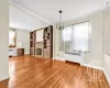 Unfurnished living room with radiator, an inviting chandelier, hardwood / wood-style floors, and a fireplace