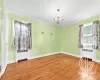 Unfurnished room with radiator, a chandelier, wood-type flooring, and ornamental molding