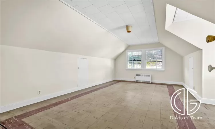 Additional living space featuring lofted ceiling and radiator