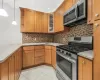 Kitchen with kitchen peninsula, stainless steel appliances, hanging light fixtures, and tasteful backsplash