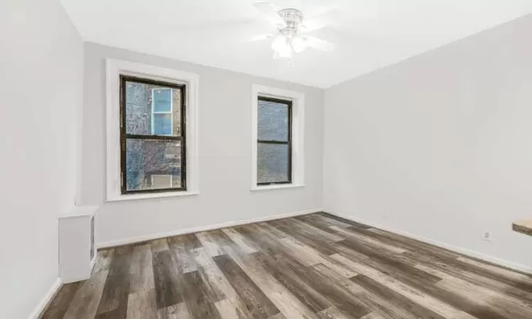 Unfurnished room featuring dark hardwood / wood-style floors and ceiling fan