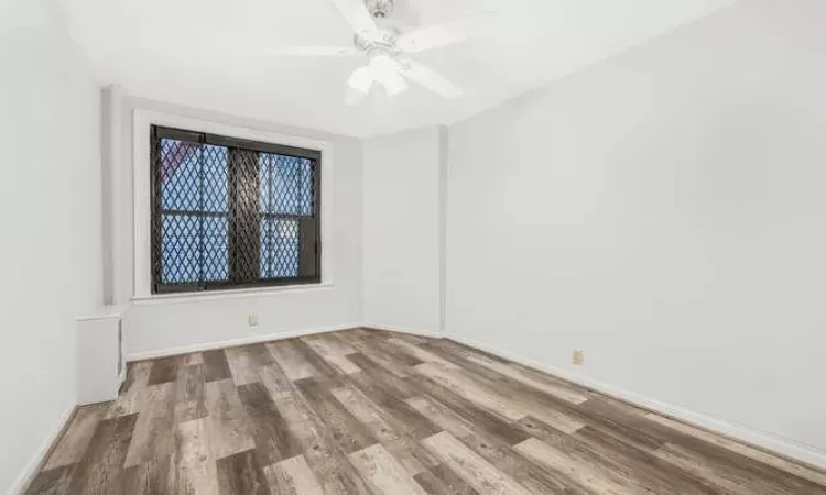 Empty room with ceiling fan and wood-type flooring