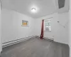 Empty room featuring a baseboard heating unit, cooling unit, and hardwood / wood-style flooring