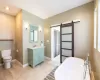 Bathroom with a tub, toilet, vanity, and hardwood / wood-style flooring