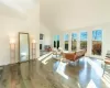 Living room with dark wood-type flooring and high vaulted ceiling