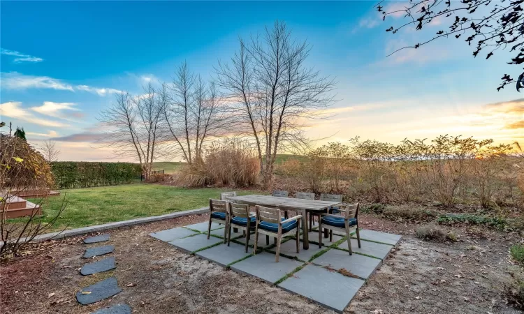 Patio terrace at dusk with a lawn