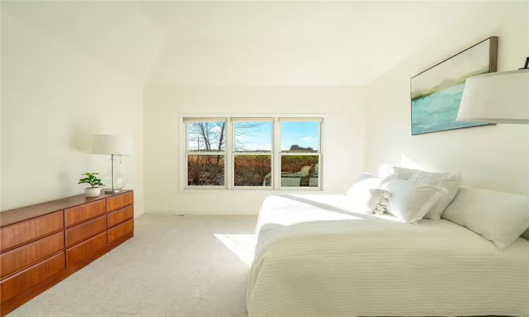 Carpeted bedroom featuring vaulted ceiling