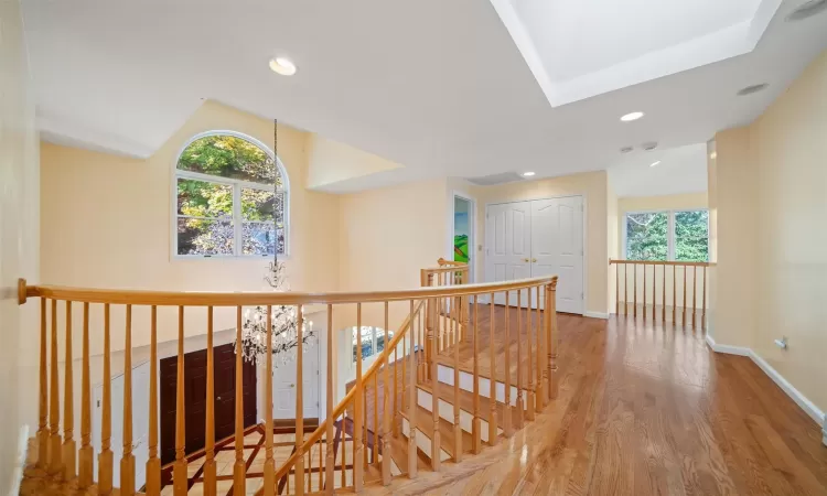 Corridor with hardwood / wood-style floors and lofted ceiling