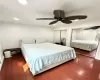 Bedroom featuring ornamental molding, two closets, ceiling fan, and dark hardwood / wood-style flooring