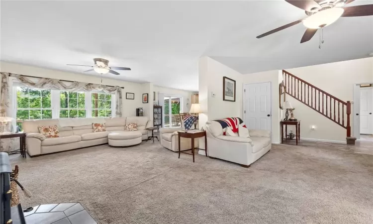 Carpeted very spacious living room featuring ceiling fan