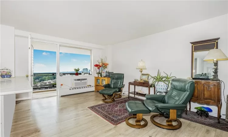 Sitting room with baseboard heating and light hardwood / wood-style floors